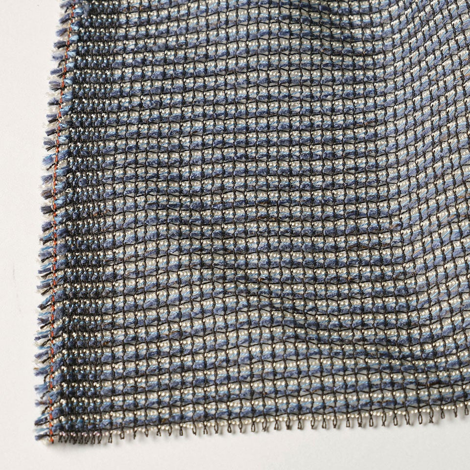 生地拡大画像／ふわりとした再生素材の糸や自社で手作りしたくるくるとした糸を、ダイヤ型に絡めるように織り上げ「懐かしさ」を表現しました