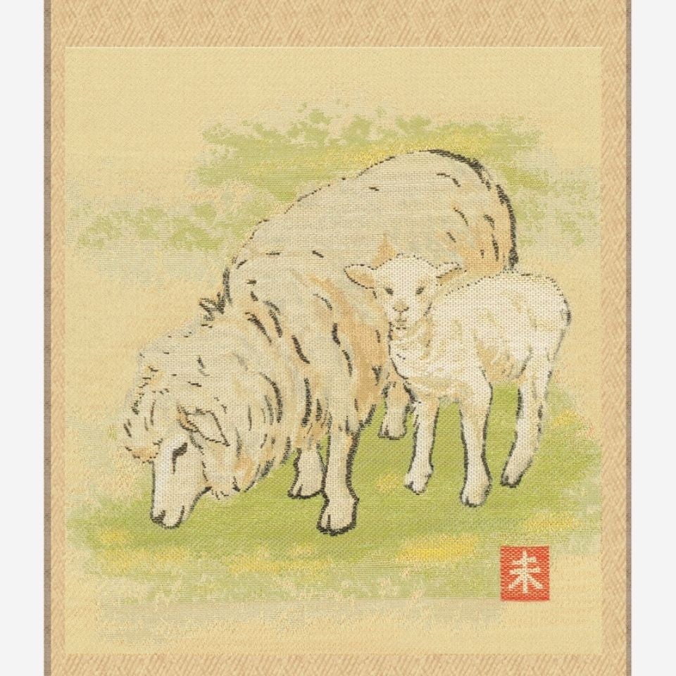 ひつじの親子がそっと寄り添い、草を食む牧歌的な優しいひとときを表現し、穏やかで心和む意匠です